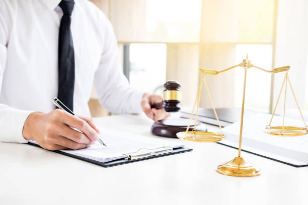 istock Midsection Of Lawyer Reading Documents While Sitting At Desk In Office 1047518512