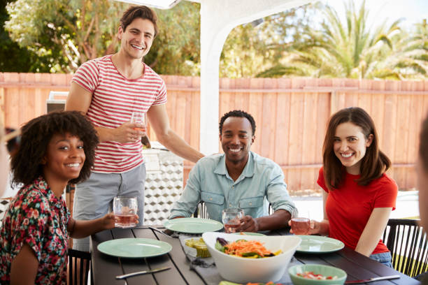 istock Adult friends sitting at a table outdoors looking at camera 1047523734