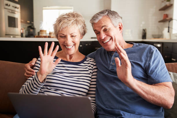 istock Senior couple video calling on a laptop waving at screen 1047528250