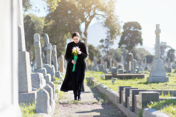 검은 꽃을 들고 묘지를 산책에 젊은 여자 - widows walk 뉴스 사진 이미지