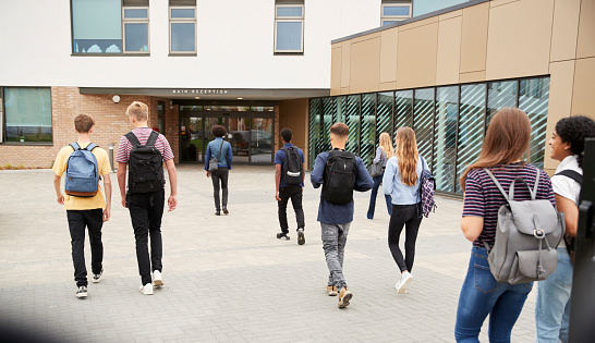 Vista posterior de estudiantes caminando en el edificio de la Universidad photo