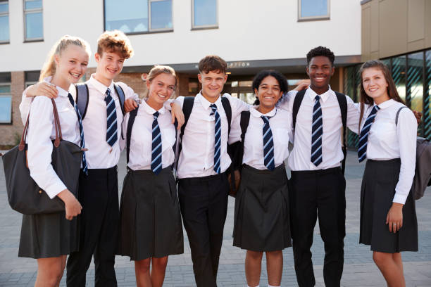 Portrait Of Smiling Male And Female High School Students Wearing Uniform Outside College Building Portrait Of Smiling Male And Female High School Students Wearing Uniform Outside College Building uniform stock pictures, royalty-free photos & images
