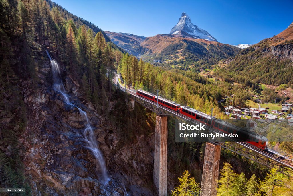 Zermatt, Switzerland. Image of Swiss Alps with Gornergrad tourist train, waterfall and Matterhorn in Valais region. Train - Vehicle Stock Photo