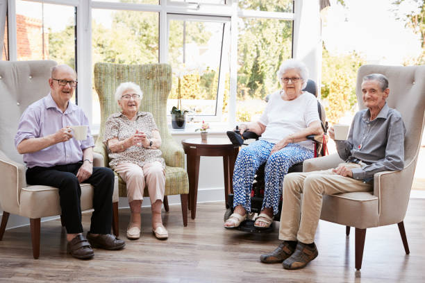 retratos de hombres y mujeres residentes sentados en sillas en el salón del hogar del jubilado - care community 80 plus years cheerful fotografías e imágenes de stock