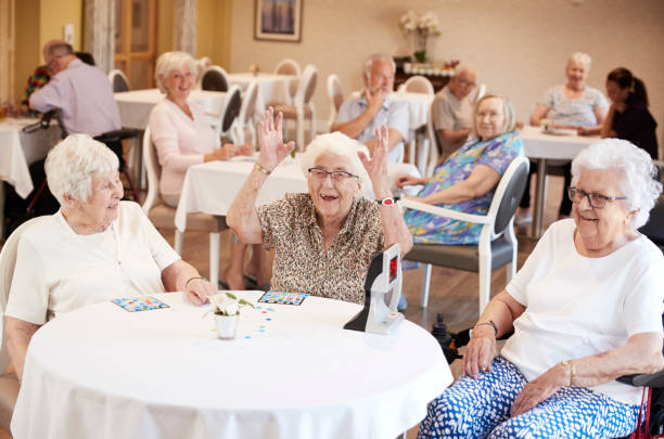 senior woman winning game of bingo in retirement home - tombola foto e immagini stock