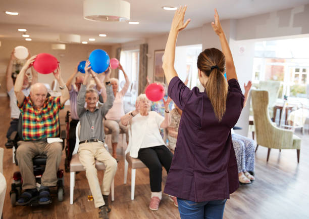 cuidador principal grupo de la tercera edad en clase de fitness en el hogar del jubilado - care community 80 plus years cheerful fotografías e imágenes de stock