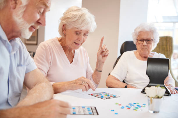 grupa seniorów gra w bingo w domu emerytalnym - one person lifestyles 80 plus years indoors zdjęcia i obrazy z banku zdjęć