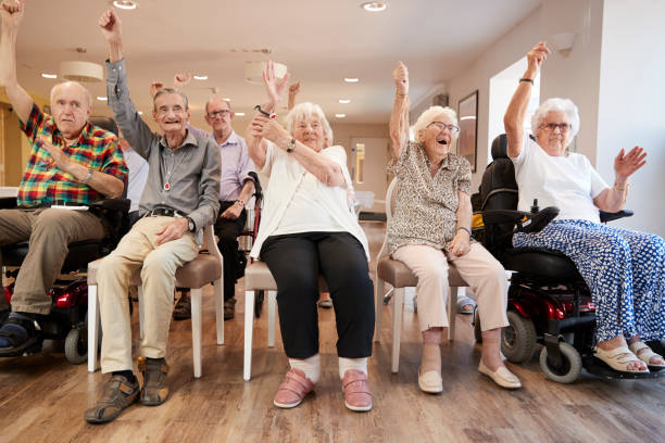 grupo de adultos mayores disfrutando de la clase de fitness en el hogar del jubilado - care community 80 plus years cheerful fotografías e imágenes de stock