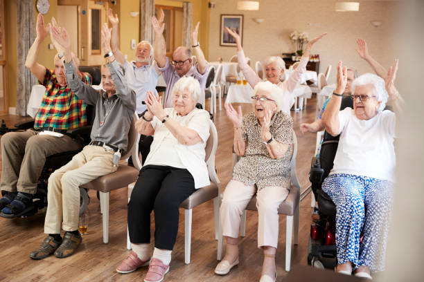 gruppe von senioren genießen fitness-klasse im seniorenheim - seniors stock-fotos und bilder