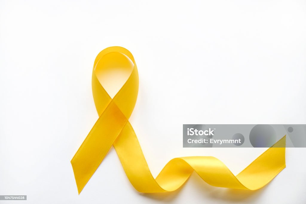 Multi meaning symbolic ribbon loop to draw attention to health issues, common illnesses. Yellow ribbon - bladder, liver and bone cancer awareness symbol. Support our troops concept. Isolated background, copy space, close up, top view, flat lay Yellow Awareness Ribbon Stock Photo