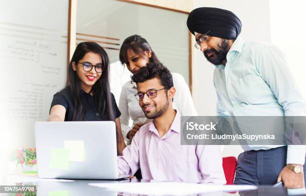 Il Team Indiano Lavora Insieme E Guarda Su Uno Schermo Di Laptop - Fotografie stock e altre immagini di India