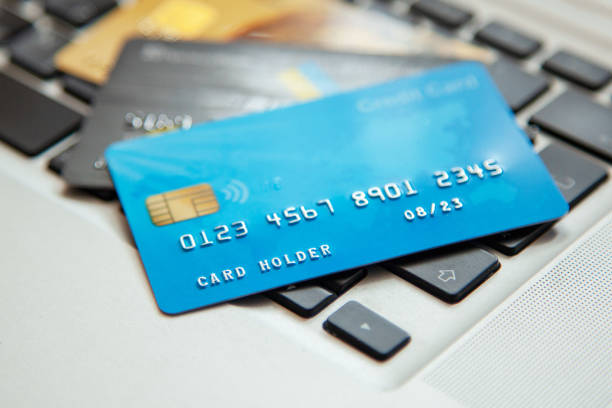 pile de cartes de crédit sur le clavier d’ordinateur portable. accès libre pour le shopping en ligne - credit card photography stack finance photos et images de collection