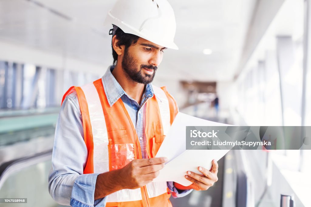 Engineer with contract Young indian engineer holding contract Construction Industry Stock Photo