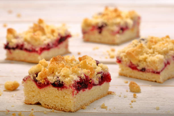 Cake with fruit and crumble on white wooden background