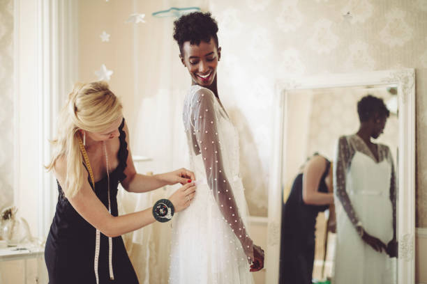 créateur de mode s’ajuste la robe de mariée - robe de mariée photos et images de collection