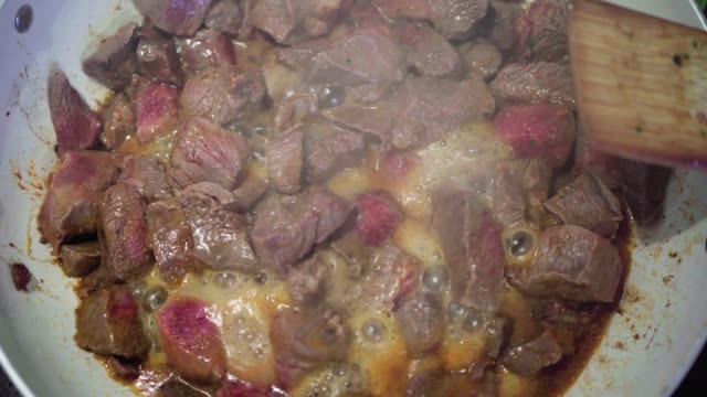 Cooking beef in a frying pan or wok for goulash or stew meal time lapse.