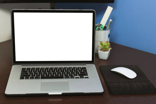 istock Desk Laptop blank text space screen in office on wood table. Laptop mock-up conceptual workspace image. 1047565444