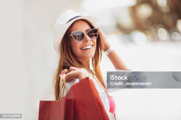 Beautiful Woman Holding Shopping Bags And Smiling Outdoors Stock Photo - Download Image Now