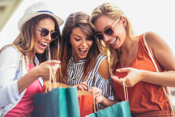 tres mujeres de compras juntos. - spending money fotos fotografías e imágenes de stock