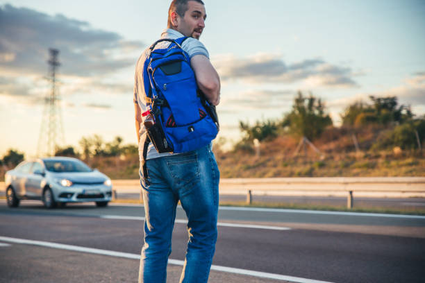 istock Man at highway looking for transport. 1047568848