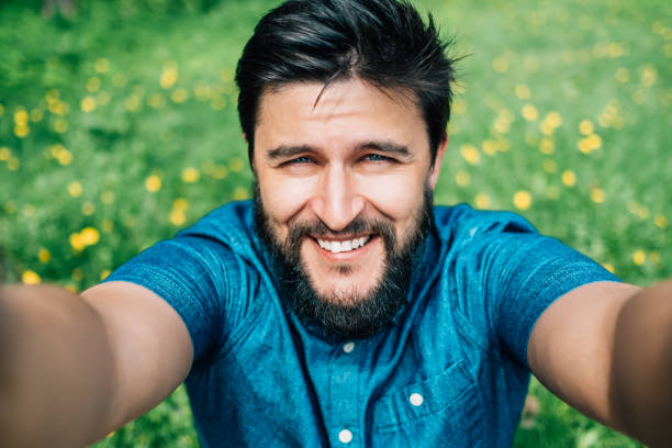 istock Man taking selfie in the forest. Holding phone by two hands 1047570712