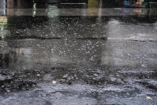 istock Raindrops on asphalt road with water ripples during heavy rain 1047573488