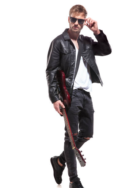 istock attractive guitarist walks to side and fixes his sunglasses 1047574460