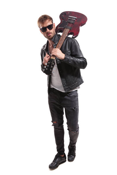 istock fashion man with guitar on shoulder walking while holding collar 1047574550