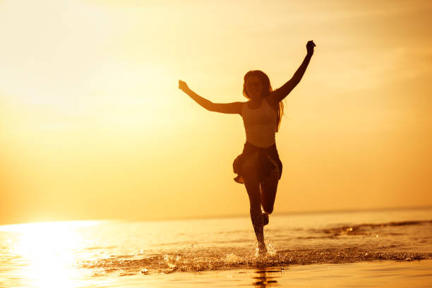 istock Happy girl run in sunset lake 1047578272