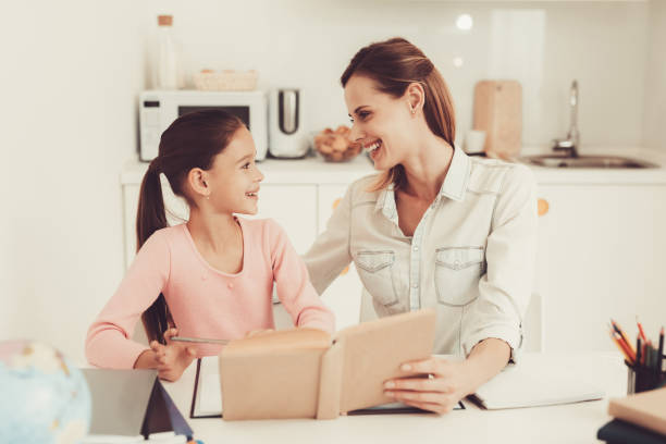 istock Mom Helps Daughter To Do Homework In The Kitchen. 1047586340