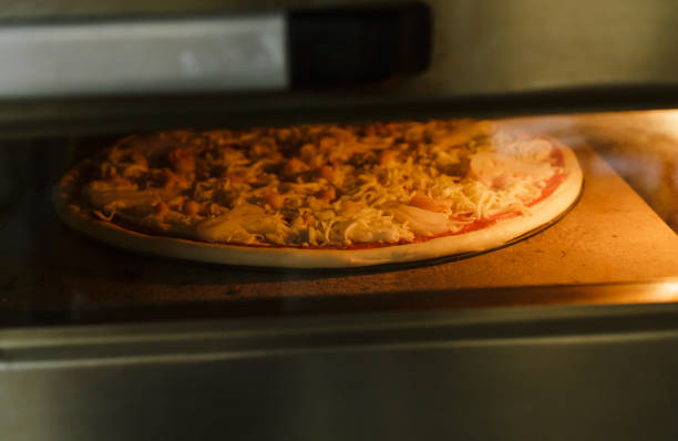 istock Putting seafood pizza into oven 1047586740
