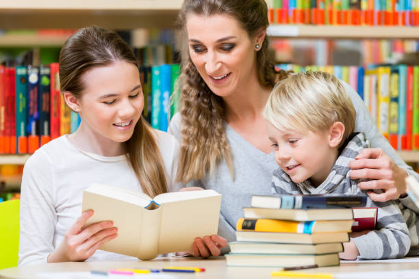 istock Class of students with their teacher in the school library 1047589114