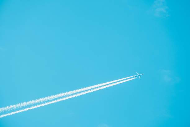 istock Long trail of jet plane on blue sky 1047589384