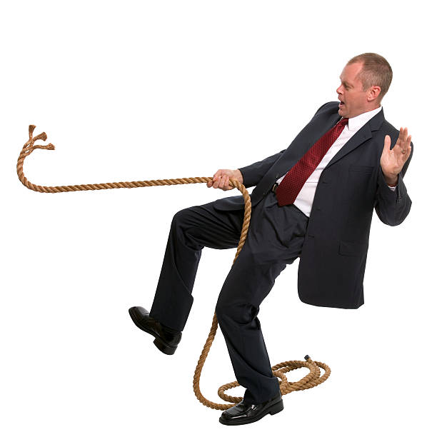 Businessman falling Businessman falling as the rope he was pulling breaks. person falling backwards stock pictures, royalty-free photos & images