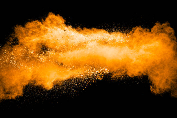 istock orange dust particles explosion on black background. Color powder dust splash. 1047606160