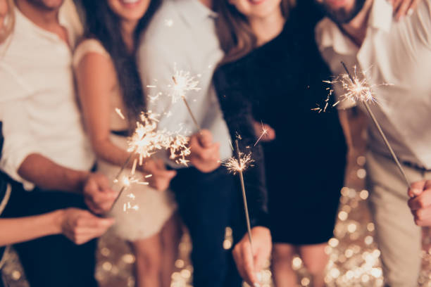 istock Cropped bengal fire sticks, sparkling, burning, elegant classy ladies and gentlemen's hands holding fire-sticks together, meeting, team, greetings, congrats 1047614190