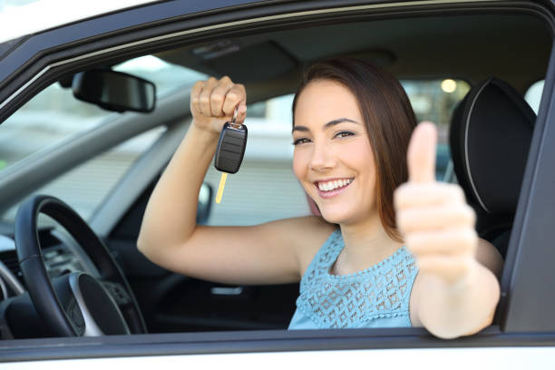 Happy car owner with a key and thumbs up Happy car owner looking at camera holding a key gesturing thumbs up reduction looking at camera finance business stock pictures, royalty-free photos & images