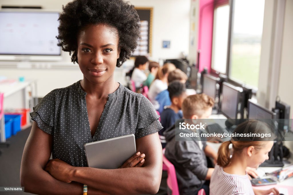 Portrait de l’enseignante titulaire ligne enseignement tablette numérique de lycéens assis devant des écrans dans les cours d’informatique - Photo de Enseignant libre de droits