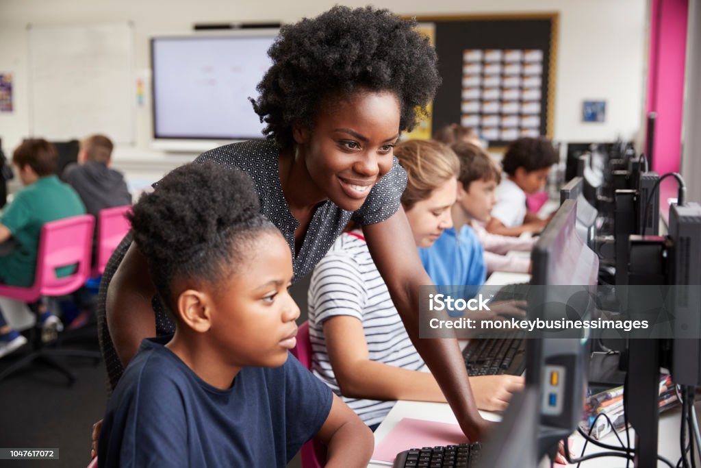 Professor, ajudando a aluna linha de estudantes do ensino médio trabalhando em telas na aula de informática - Foto de stock de Professor royalty-free