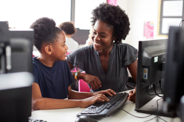 istock Teacher Helping Female High School Student Working at Screen In Computer Class 1047617112