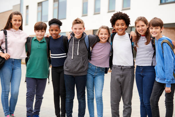 Portrait Of High School Student Group Standing Outside School Buildings Portrait Of High School Student Group Standing Outside School Buildings arm in arm stock pictures, royalty-free photos & images