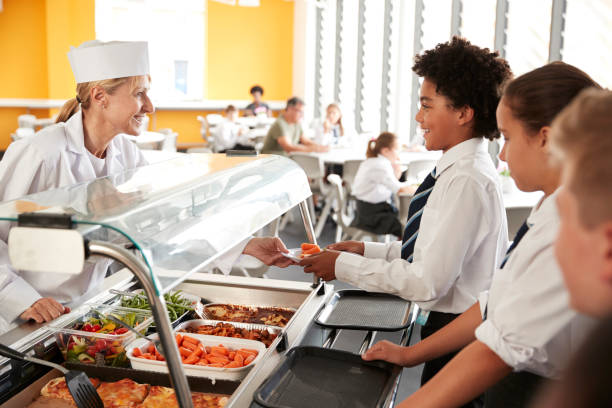 istock High School Students Wearing Uniform Being Served Food In Canteen 1047617708