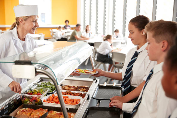 istock High School Students Wearing Uniform Being Served Food In Canteen 1047617810