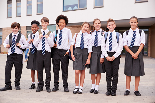 Retrato de grupo de estudiantes de secundaria con uniforme exterior escuela edificios photo
