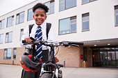 istock Portrait Of Female High School Student Wearing Uniform With Bicycle Outside School Buildings 1047620658
