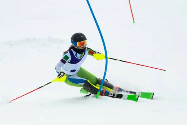 Front view of young female alpine skier at slalom