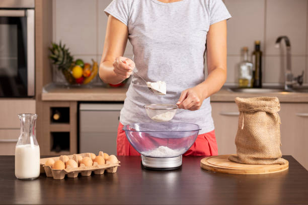 istock Woman sieving and measuring flour 1047621178