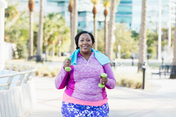 istock African-American woman exercising with hand weights 1047627856
