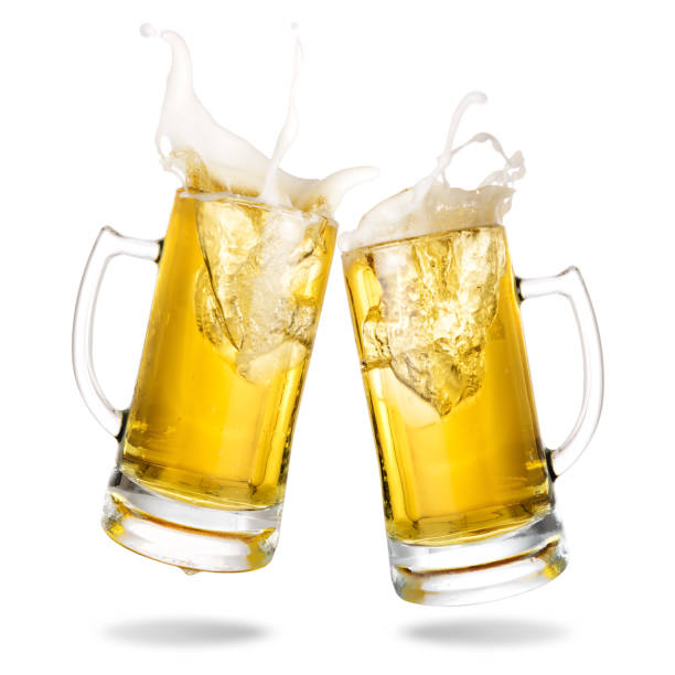 Cheering beer Cheers cold beer with splash out of mug isolated on white background. beer glass splash stock pictures, royalty-free photos & images