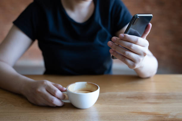 istock female model holds modern smart phone   relaxing in cafe coffee 1047634774